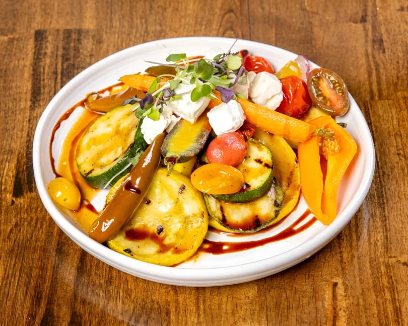 Grilled zucchini, squash, bell peppers, and tomatoes with feta cheese and balsamic glaze.
